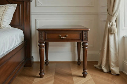Classic solid wood bedside table with a single drawer, antique brass handle, and fluted legs to match the circular bed.