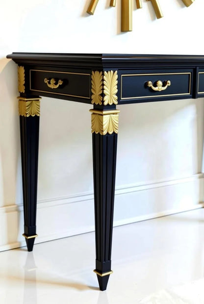 Detailed view of black Empire console table featuring three drawers, gold ormolu handles, acanthus leaf sabots, and fluted legs – Hollywood Regency elegance