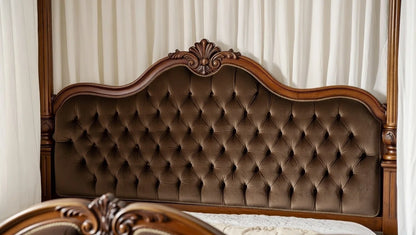 Close up detail of ornate hand-carved motifs on the solid mahogany headboard of the Victorian bed.