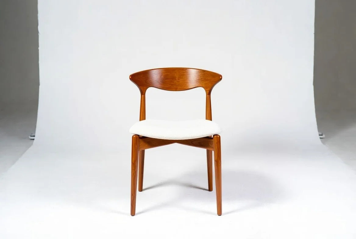 Mid-century modern "Cow Horn" dining chair in solid walnut with curved sculptural back, white upholstered seat, and tapered legs, Danish design
