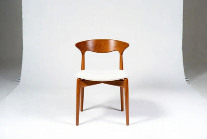 Mid-century modern "Cow Horn" dining chair in solid walnut with curved sculptural back, white upholstered seat, and tapered legs, Danish design