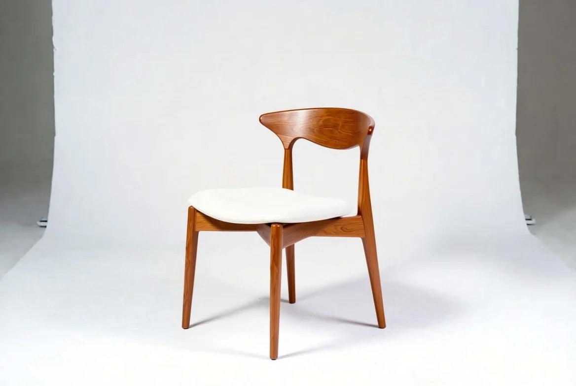 Handcrafted walnut mid-century dining chair with iconic cow horn shaped backrest, padded white seat, and elegant tapered legs, retro minimalist style