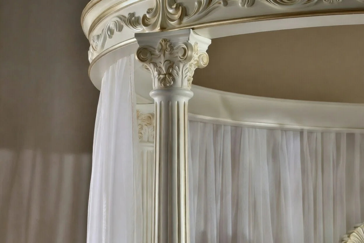 Close-up of an ornate canopy bed with white curtains.
