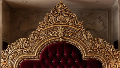 Detailed shot of the intricate antique gold leaf scrollwork and burgundy velvet upholstery on the headboard