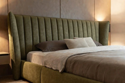 Angled view of solid wood shelter bed highlighting upholstered wingback headboard and low platform design